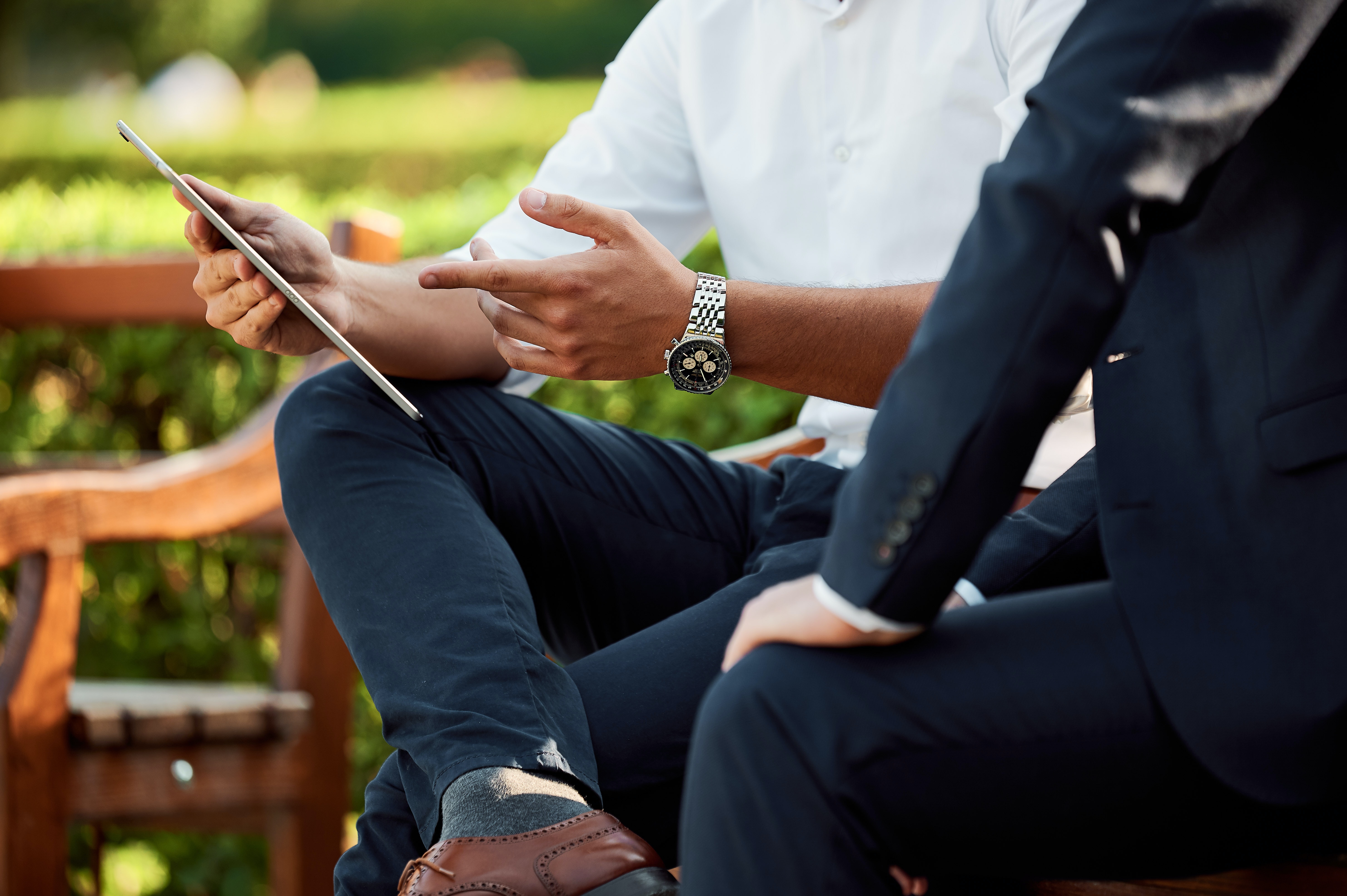 two people sitting pointing to a tablet